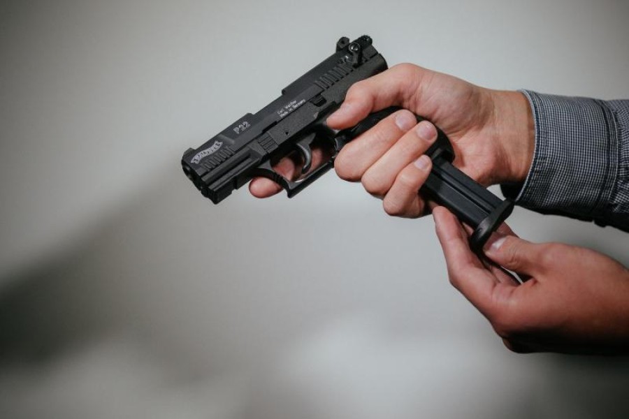 Hände laden eine Schreckschuss-Pistole "Walther P22" mit einem Magazin