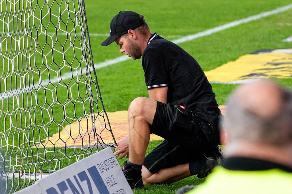 Ein Sandhäuser Mitarbeiter flickt gegen Eintracht Braunschweig das Tornetz.