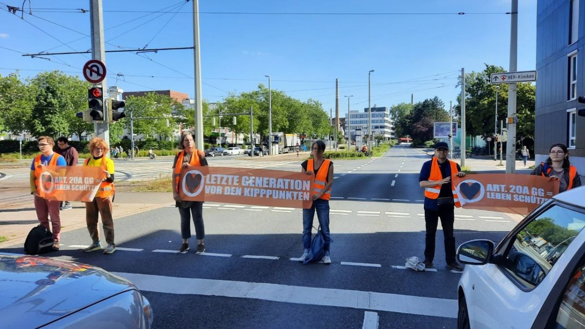 Aktivisten der letzten Generation stehen auf einer StraÃŸe in Braunschweig und blockieren den Verkehr