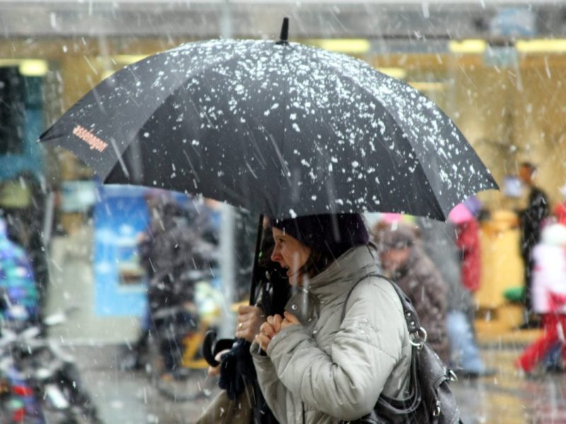 Frau mit Regenschirm im Schnee