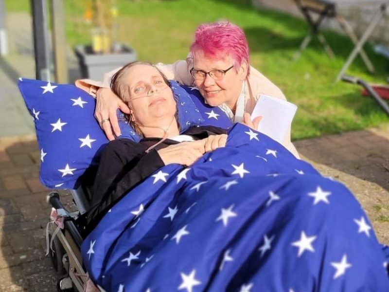 Vorm Standesamt kann Elisabeth wenigstens für ein paar Augenblicke die Sonne genießen. Schon so lange kann sie ihre Wohnung aus eigener Kraft nicht mehr verlassen. Ihre Schwester ist an ihrer Seite.